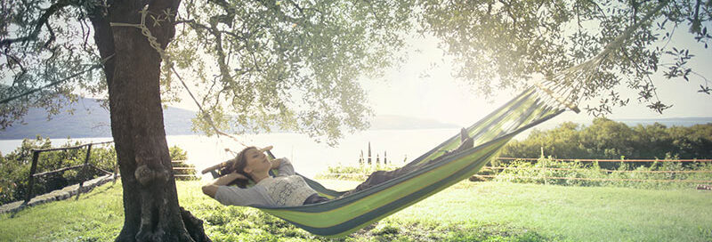 Frau-liegt-in-einer-Hängematte-unter-Bäumen